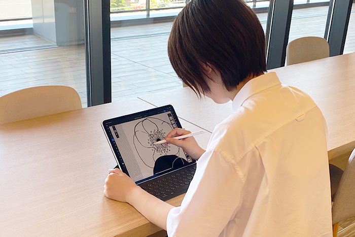 20周年記念WEBページ用にデザインを作成する橋本。